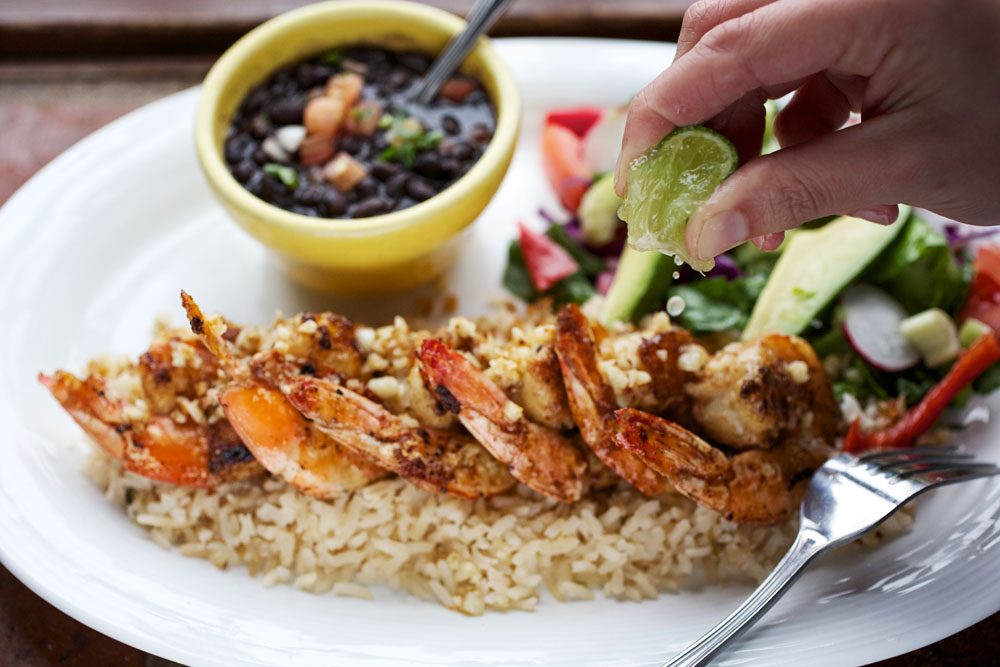 grilled shrimp on rice with fresh lime juiced on top